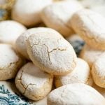 A close up of an Italian almond cookie with cracks and powdered sugar