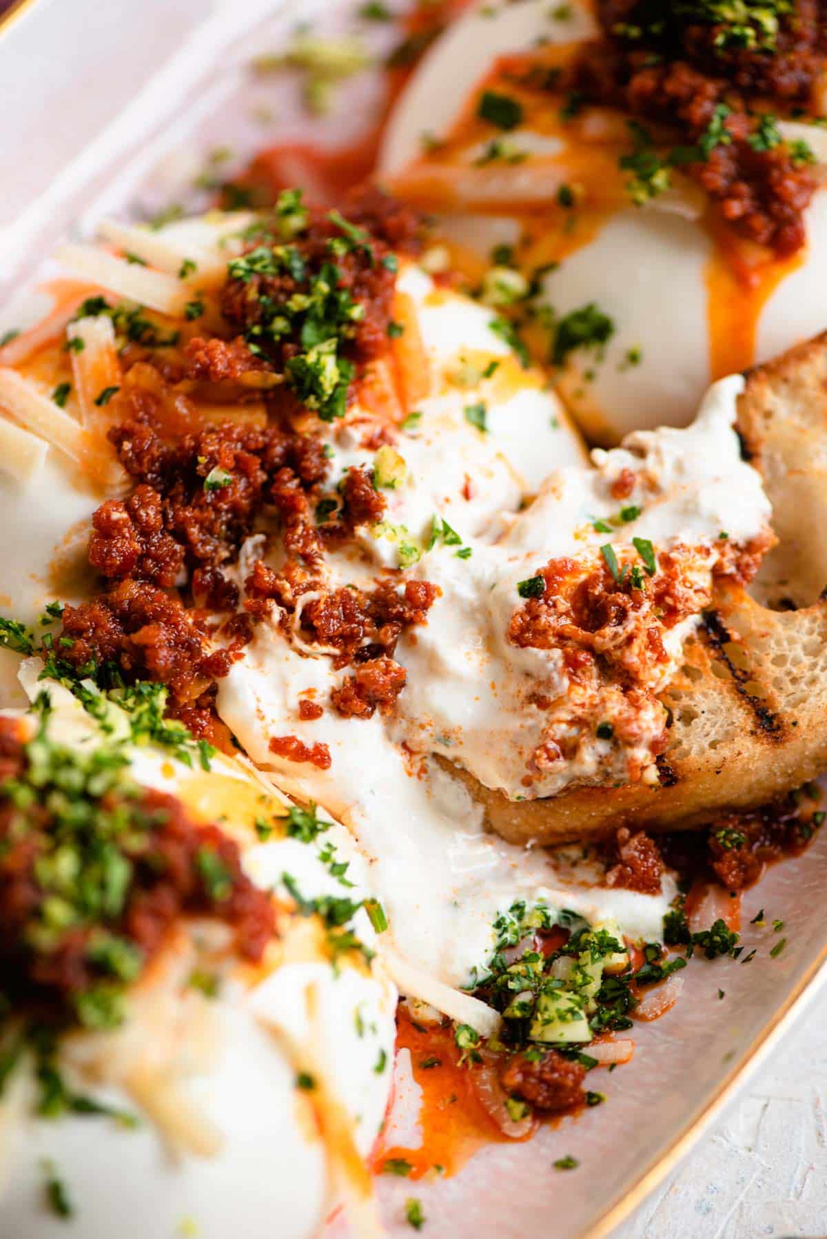 A close up of burrata cheese with 'Nduja and ciabatta bread