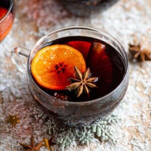 Mulled wine in a glass mug with orange and star anise inside it