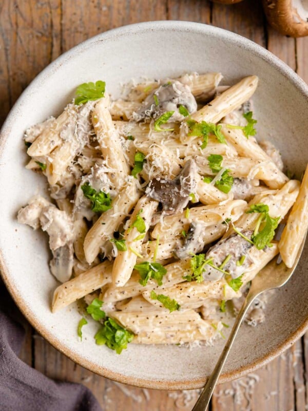 An overhead shot of pasta in a bowl with mushrooms and sausage