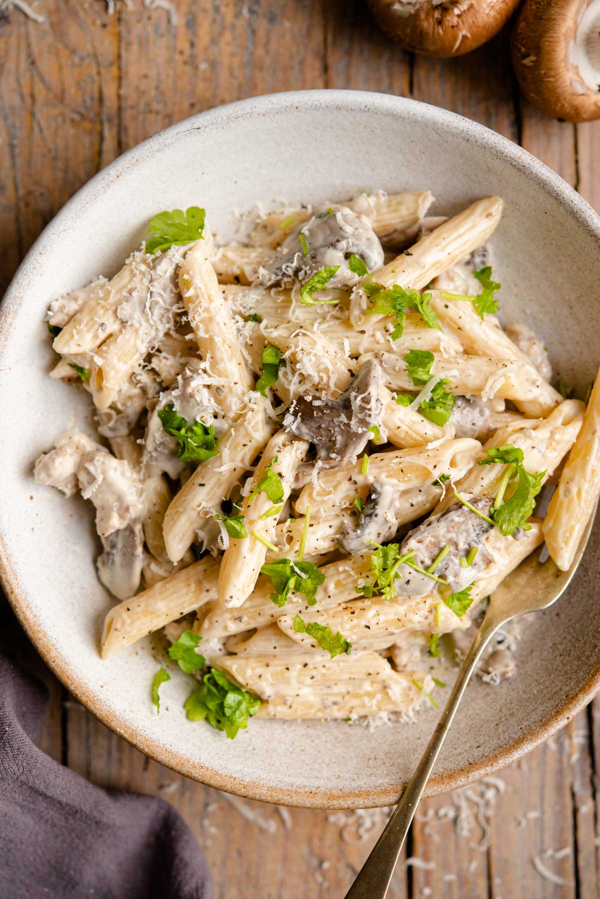 An overhead shot of pasta in a bowl with mushrooms and sausage