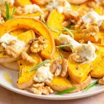 A close up of roasted butternut squash and gorgonzola on a serving plate
