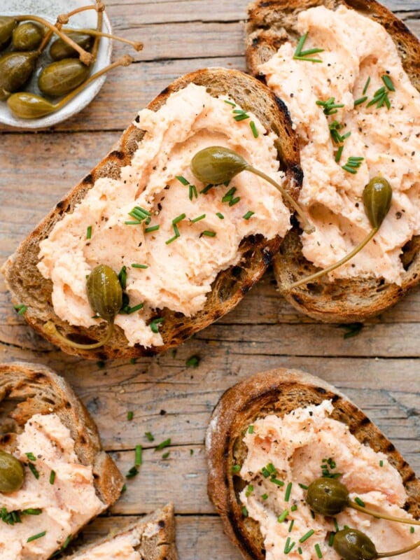 An overhead shot of smoked salmon crostini on a wooden surface