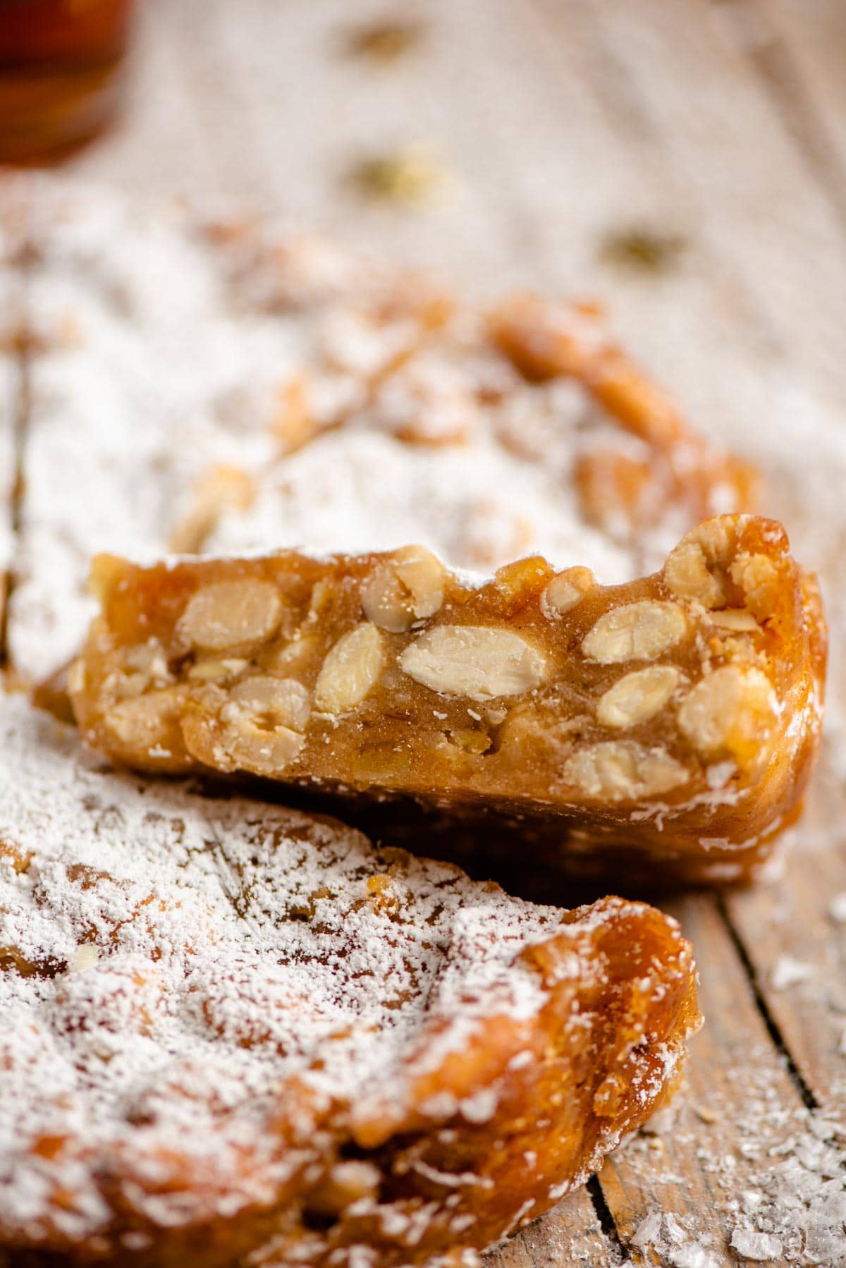 A close up of a cut slice on panforte showing all the nuts and fruit inside