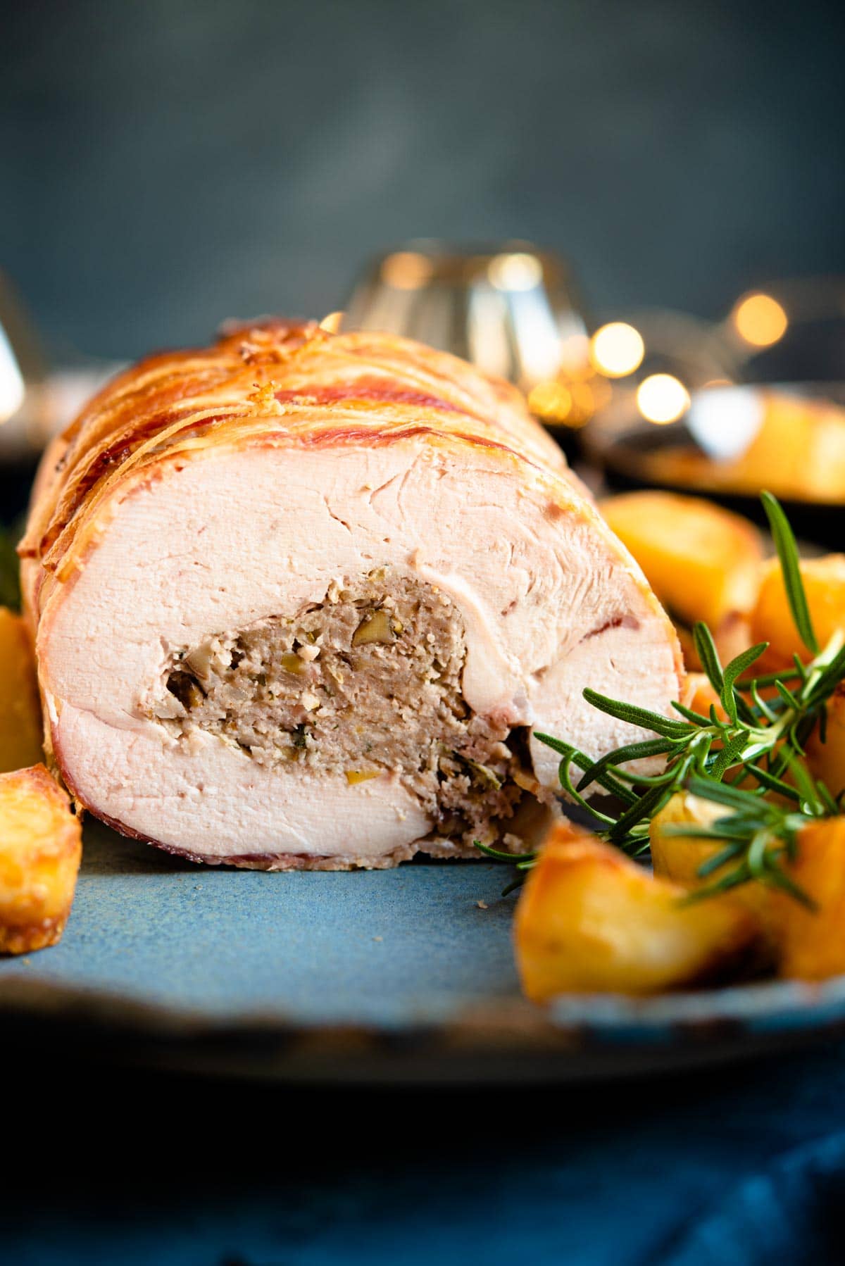 A close up of sausage and chestnut stuffed turkey breast on a serving plate