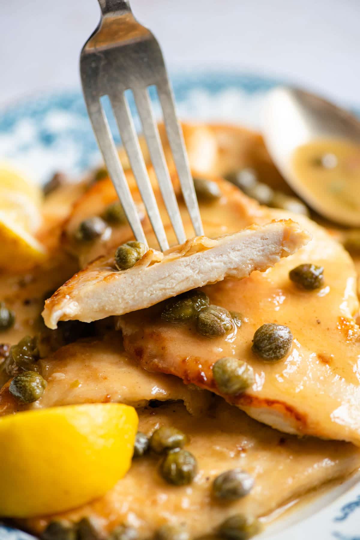 A piece of chicken piccata on a fork