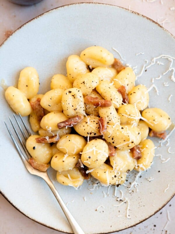 An overhead shot of a plate of gnocchi with carbonara sauce