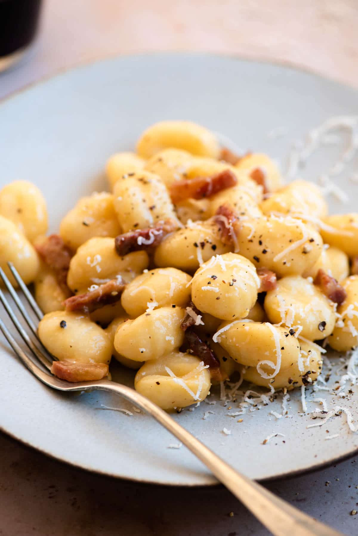 A close up of gnocchi carbonara on a plate