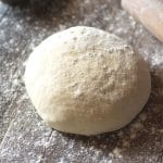 A ball of yeast free pizza dough on a wooden surface