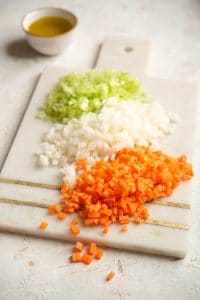 Finely chopped carrot, celery and onion on a chopping board