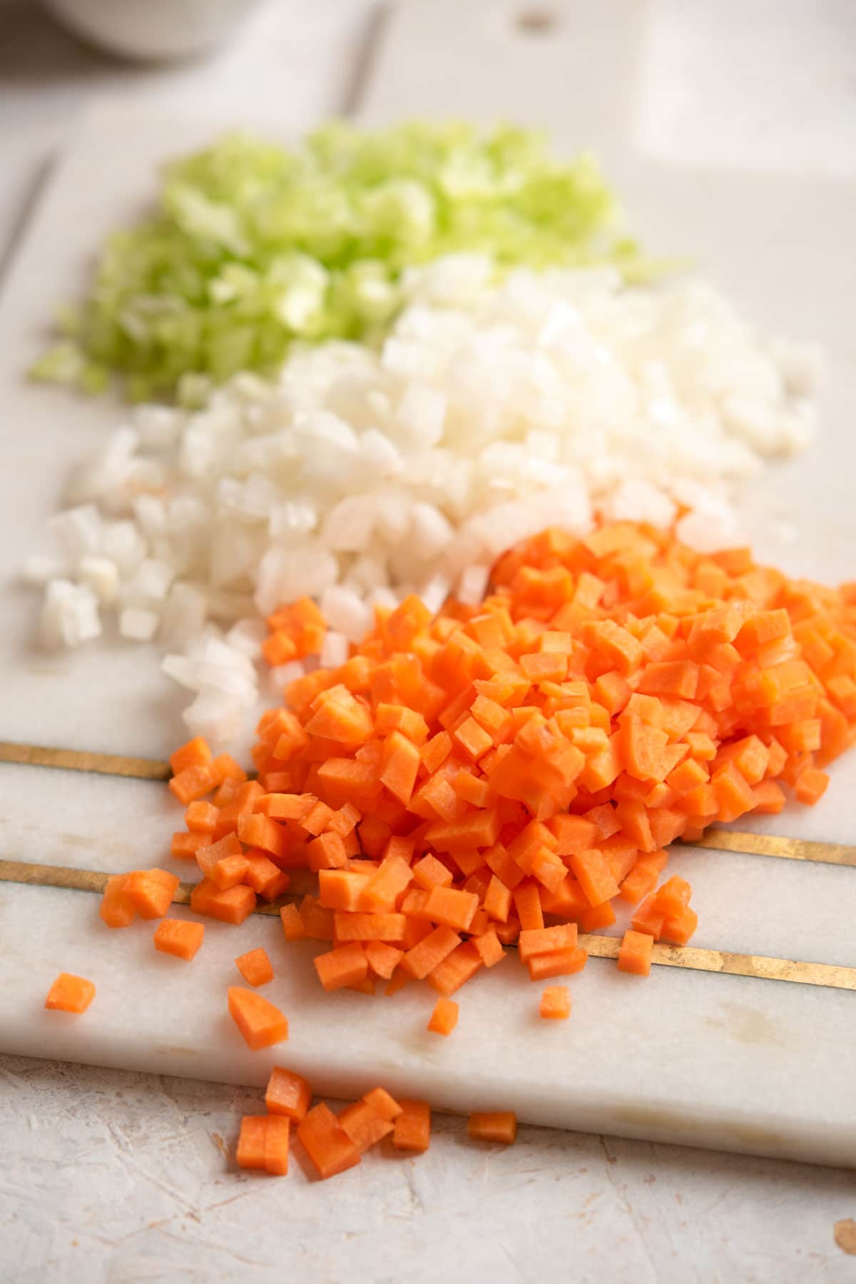 A close up of finely chopped soffritto on a board