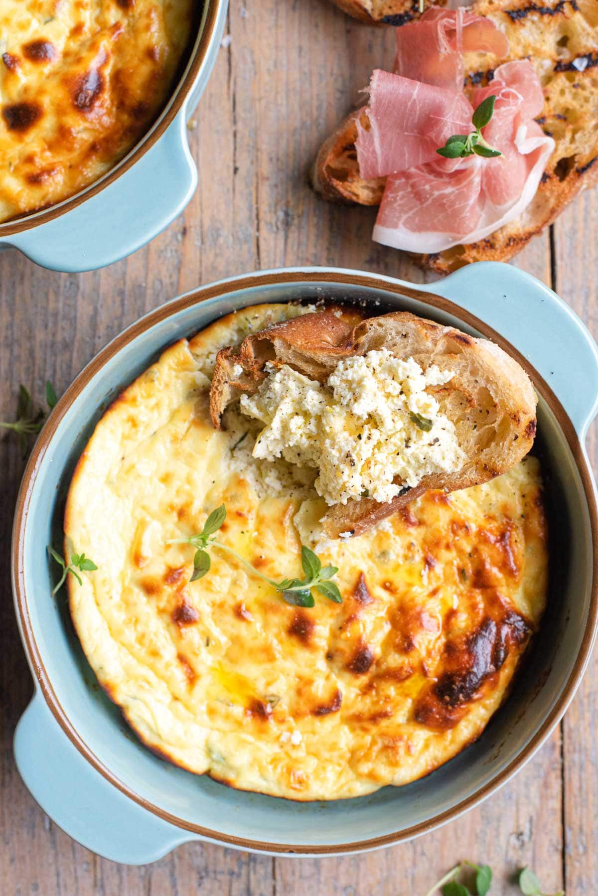 A close up of baked ricotta in a dish and on some bread