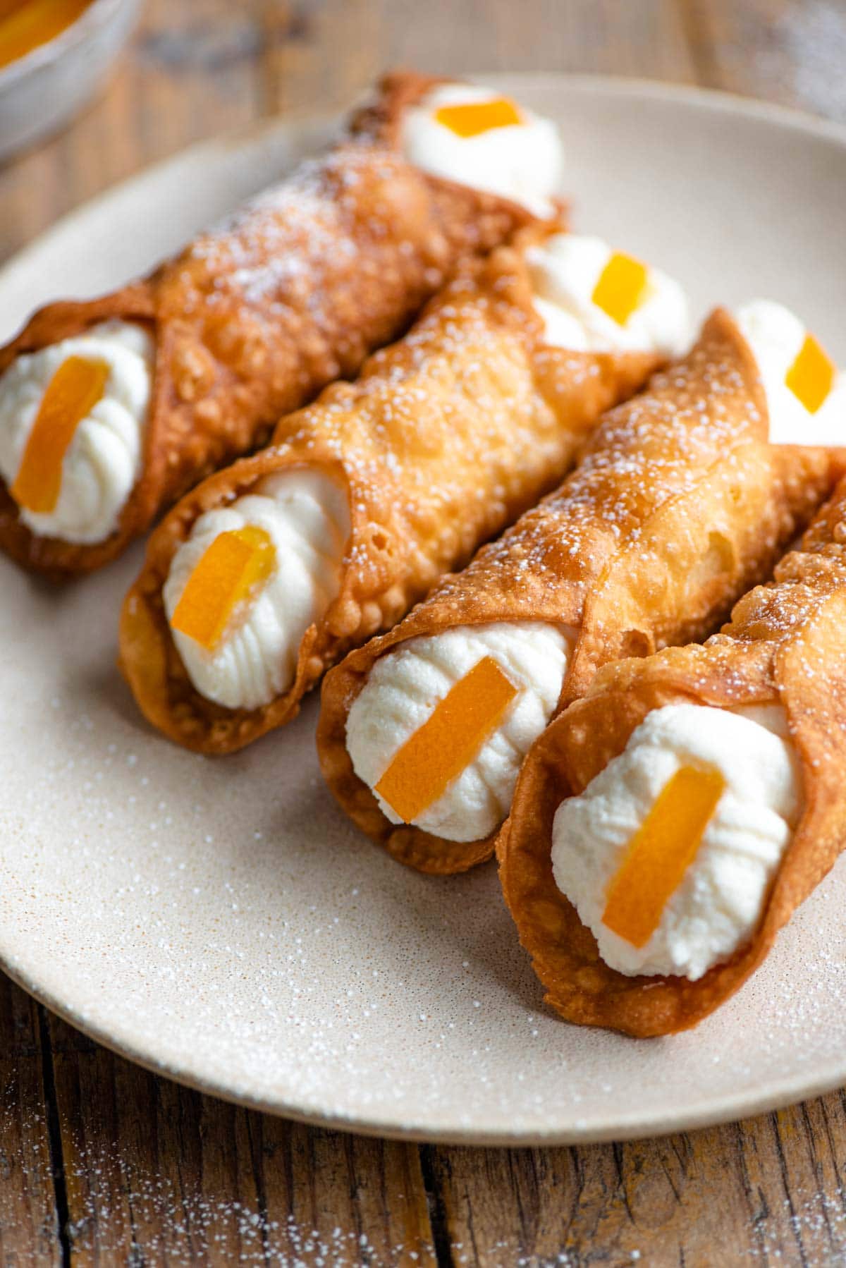 A close up of four cannoli filled with ricotta