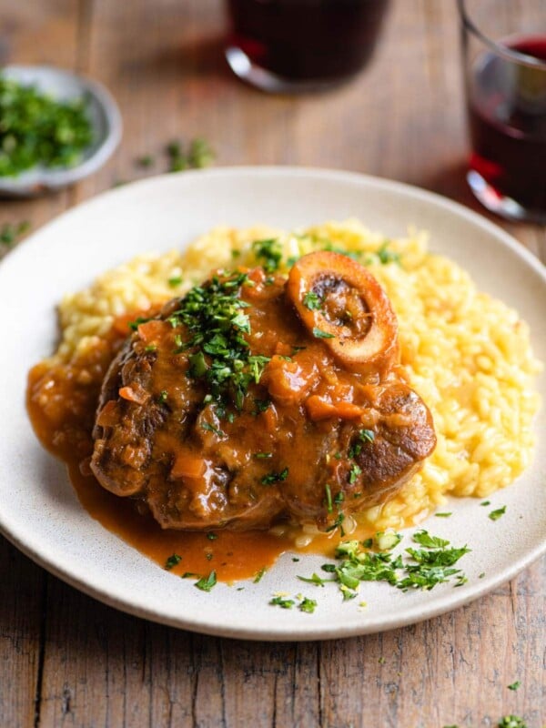Osso Bucco on a plate of saffron risotto and topped with gremolata