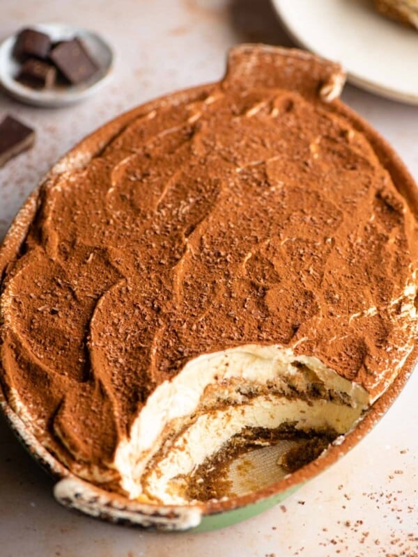 An oval dish of Tiramisu with a scoop out