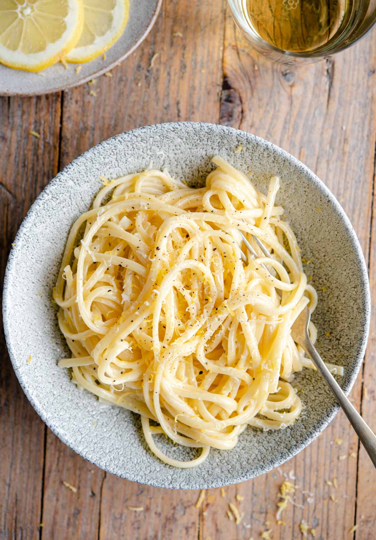 A bowl of creamy lemon pasta on a wooden surface