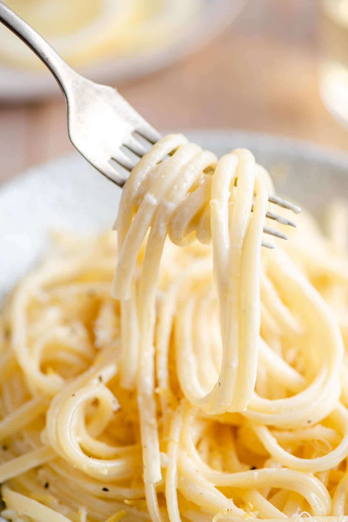 A close up of creamy lemon pasta on a fork