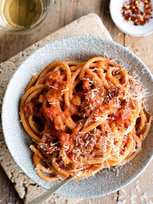 An overhead shot of a bowl of Bucatini all'Amatriciana topped with pecorino cheese