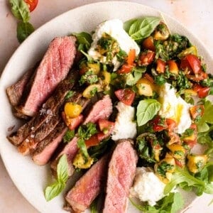 Steak tagliata on a plate with tomato and mozzarella salad