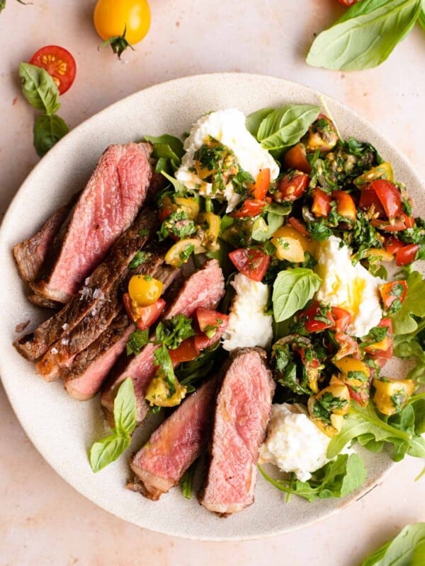 Steak tagliata on a plate with tomato and mozzarella salad