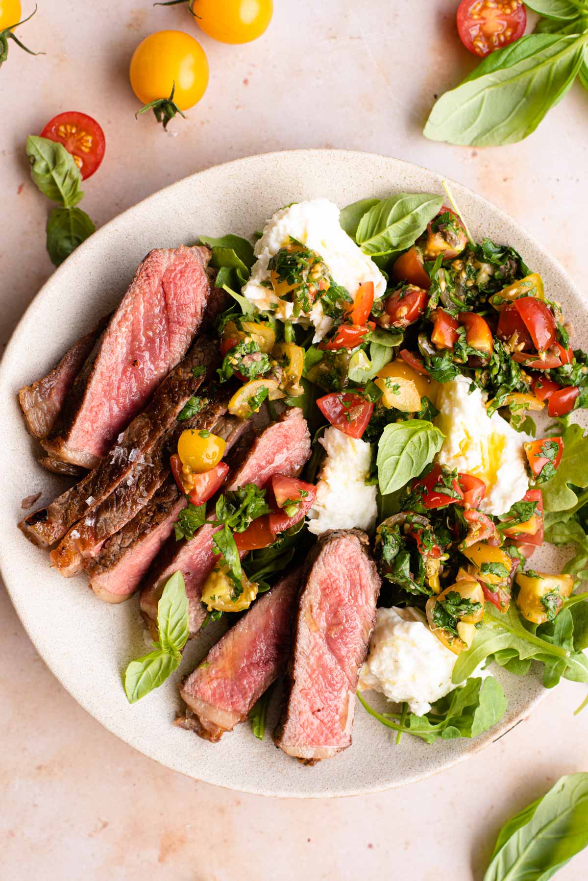 Steak tagliata on a plate with tomato and mozzarella salad