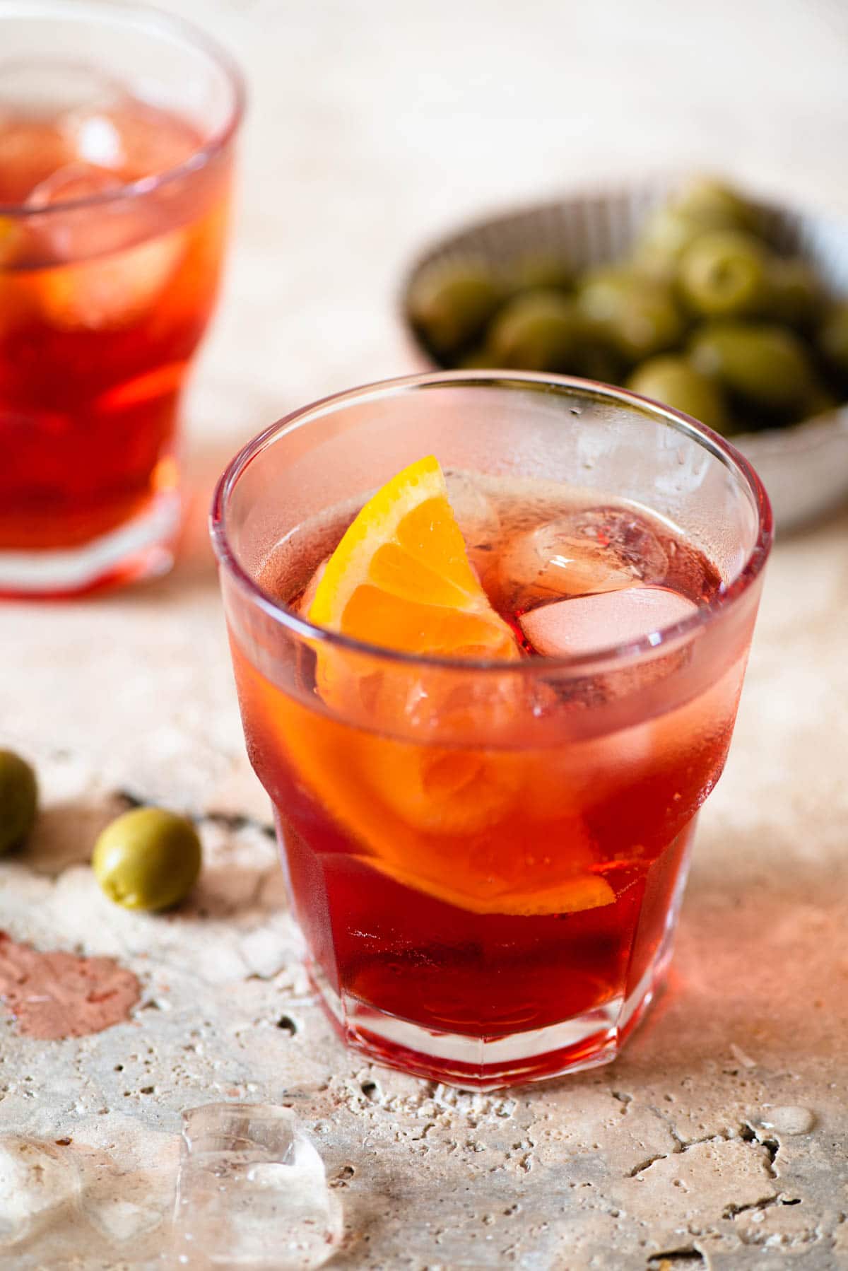 A close up of an Americano cocktail with a slice of orange