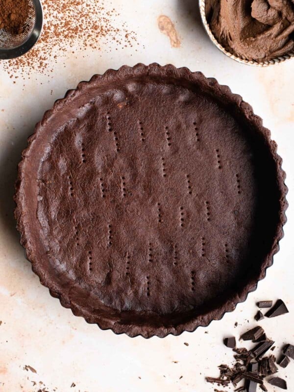 An overhead shot of chocolate pastry in a tart pan ready to be baked