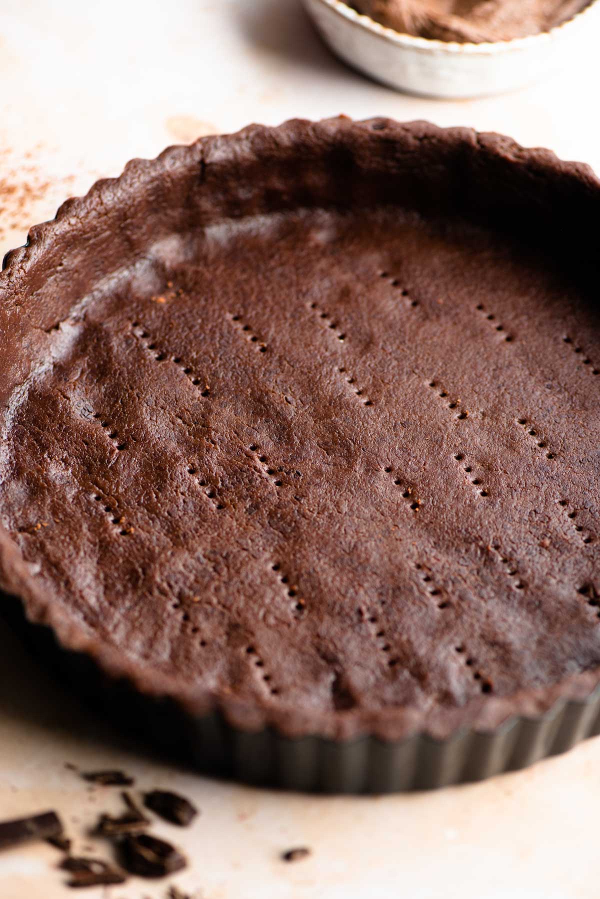 A close up of chocolate shortcrust pastry in a tart pan