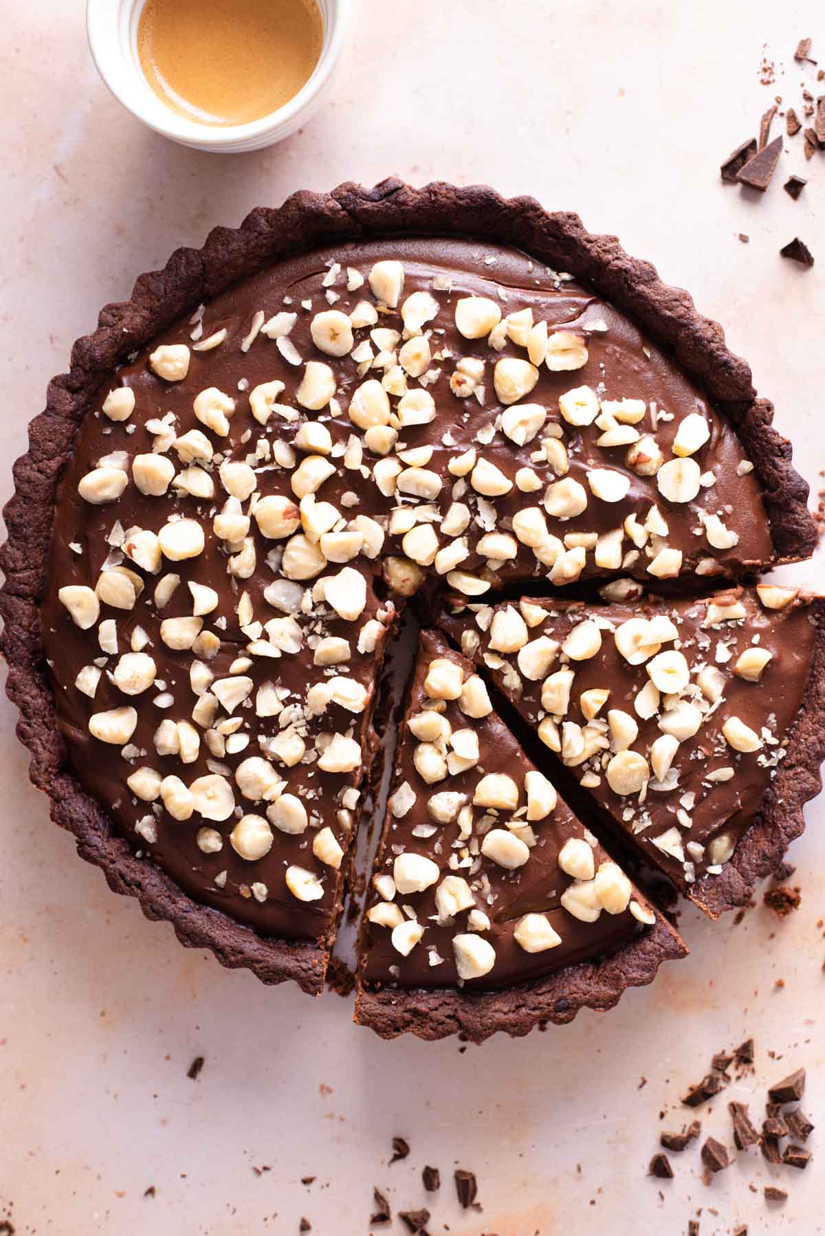 An overhead shot of a chocolate tart topped with hazelnuts