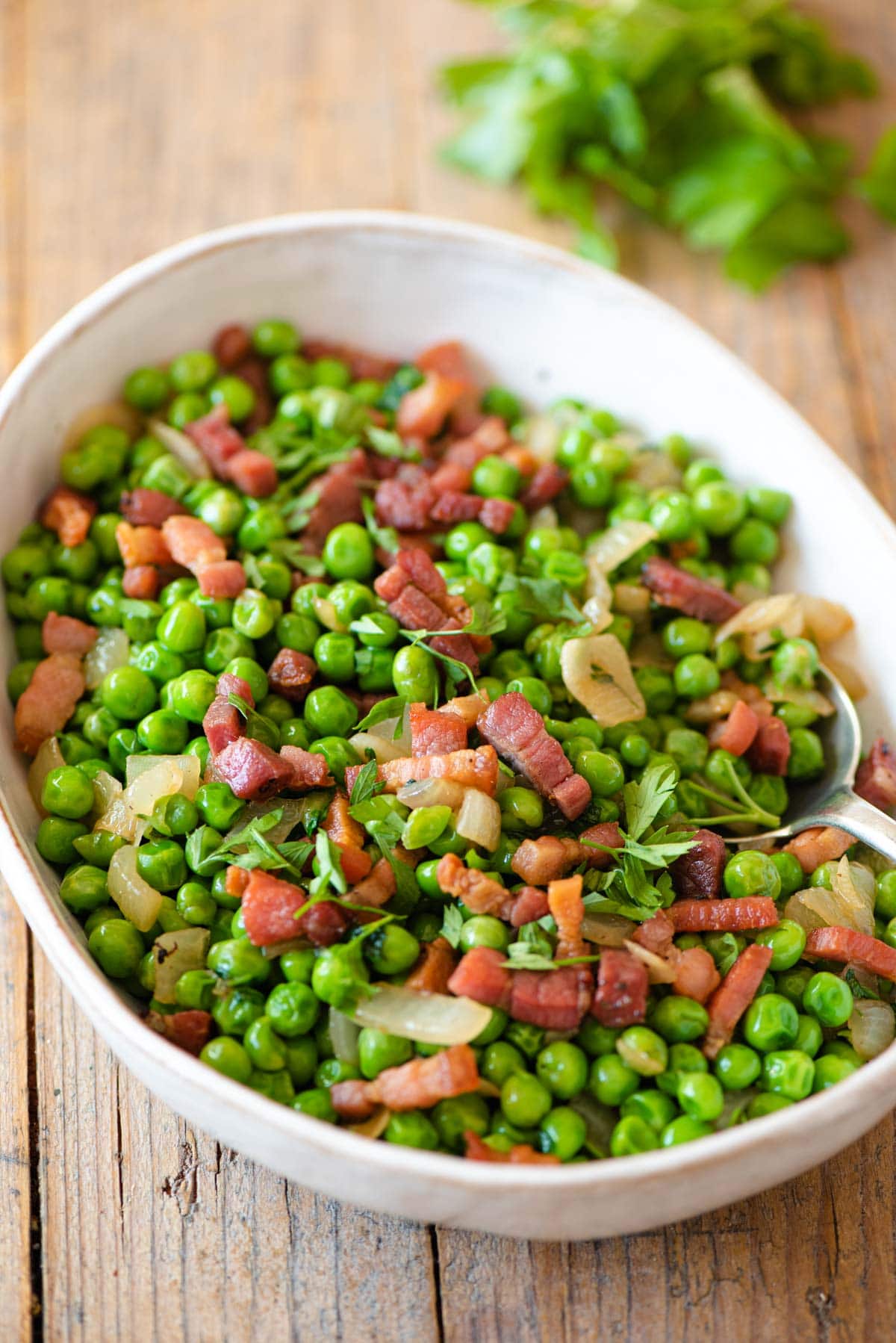 Peas and pancetta in a large serving bowl