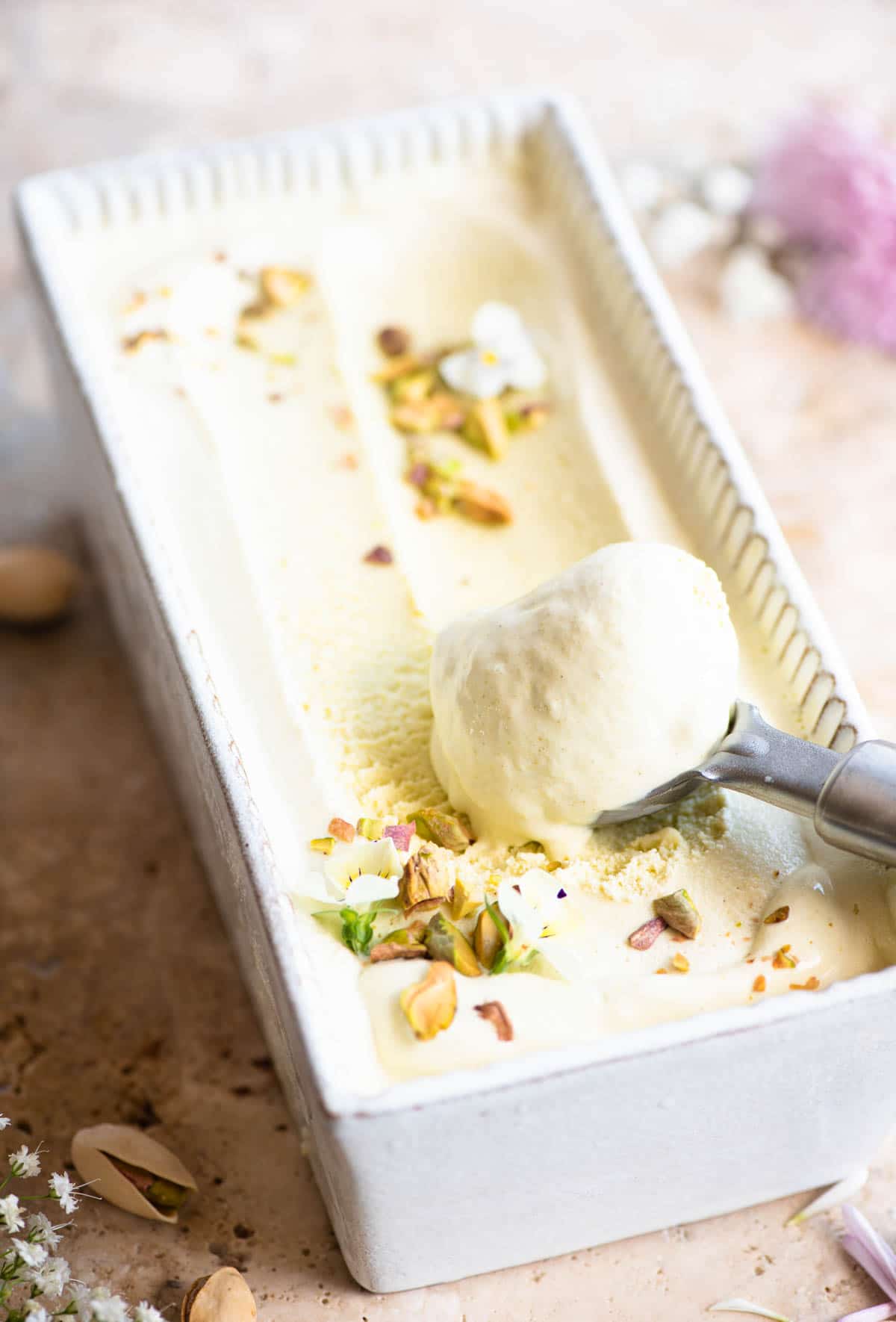 Pistachio ice cream in a loaf dish with a sccop of ice cream at one end