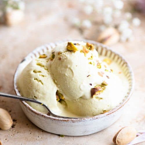 Three scoops of pistachio ice cream in a rustic looking ramekin