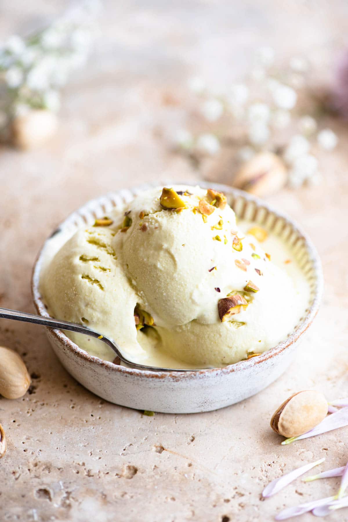 Three scoops of pistachio ice cream in a rustic looking ramekin