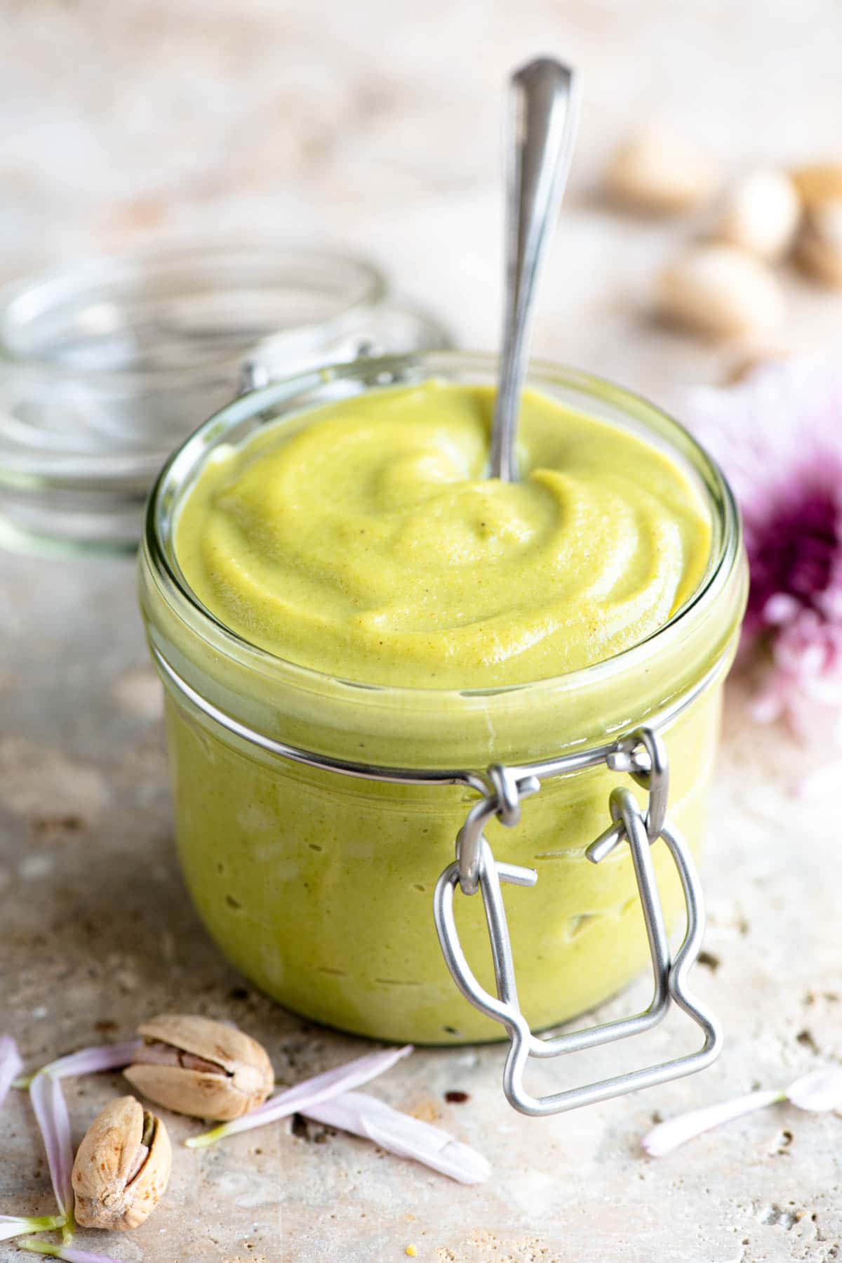 A jar of pistachio cream with a spoon in it