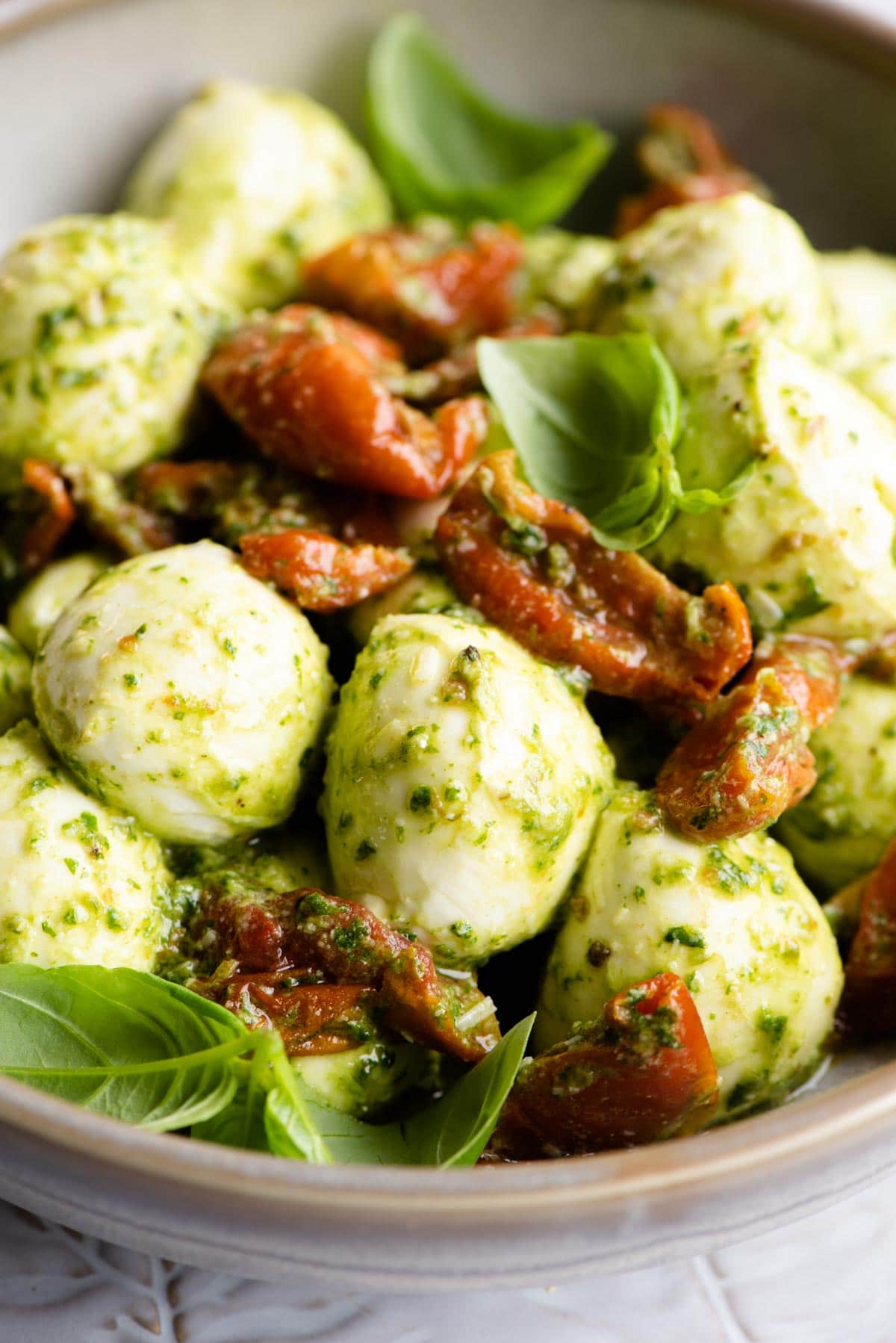 A close up of mozzarella bocconcini balls with tomatoes and pesto