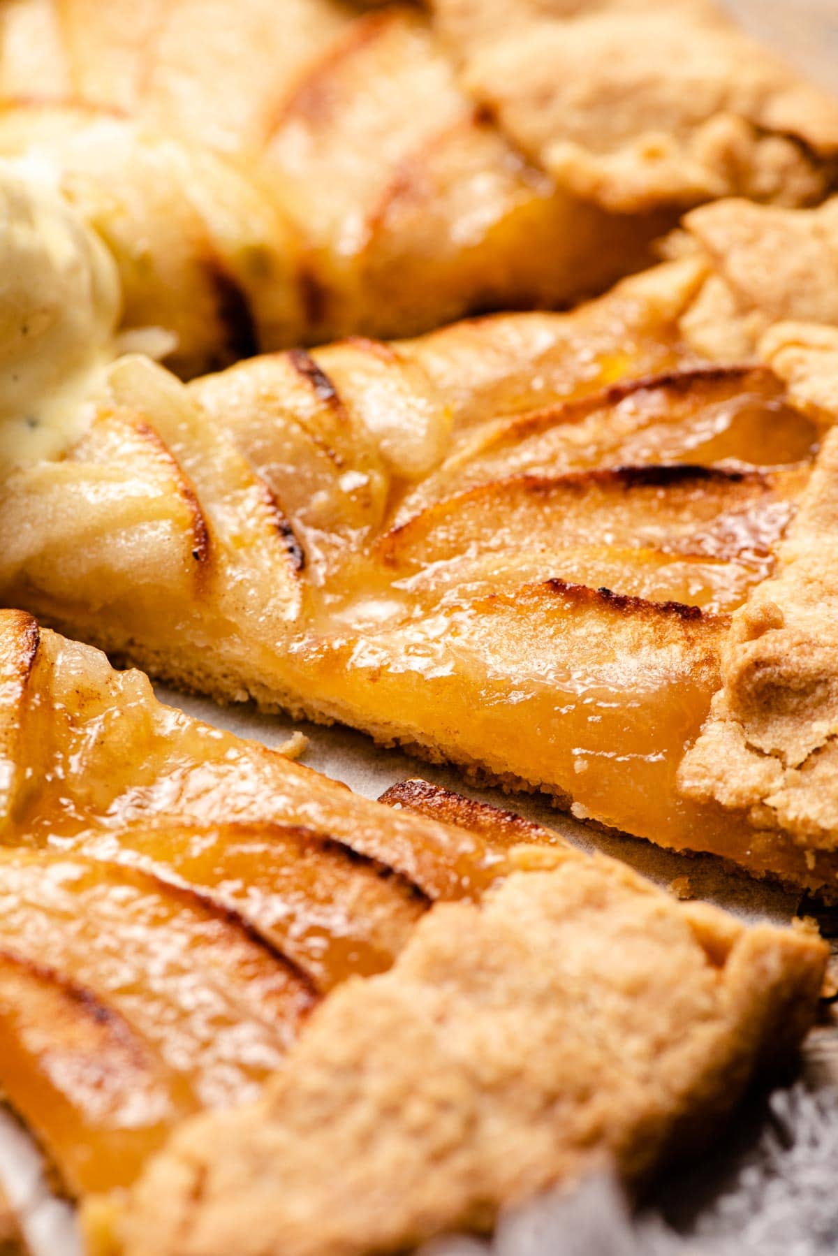 A close up of a slice of apple crostata with apricot jam