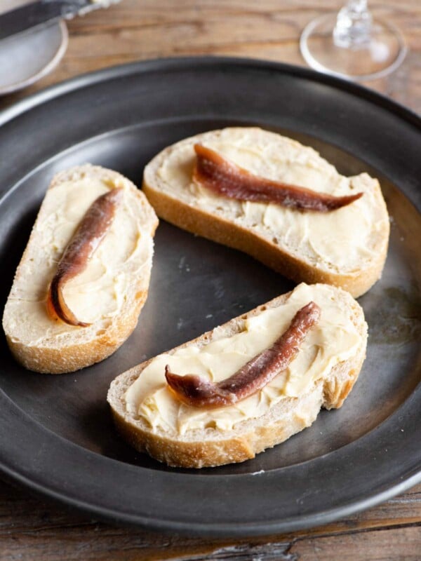 Three slices of bread with butter and anchovies