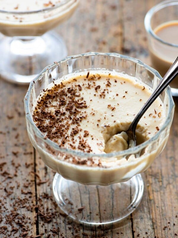 Baileys panna cotta in a small glass dish with a spoon and grated chocolate on top