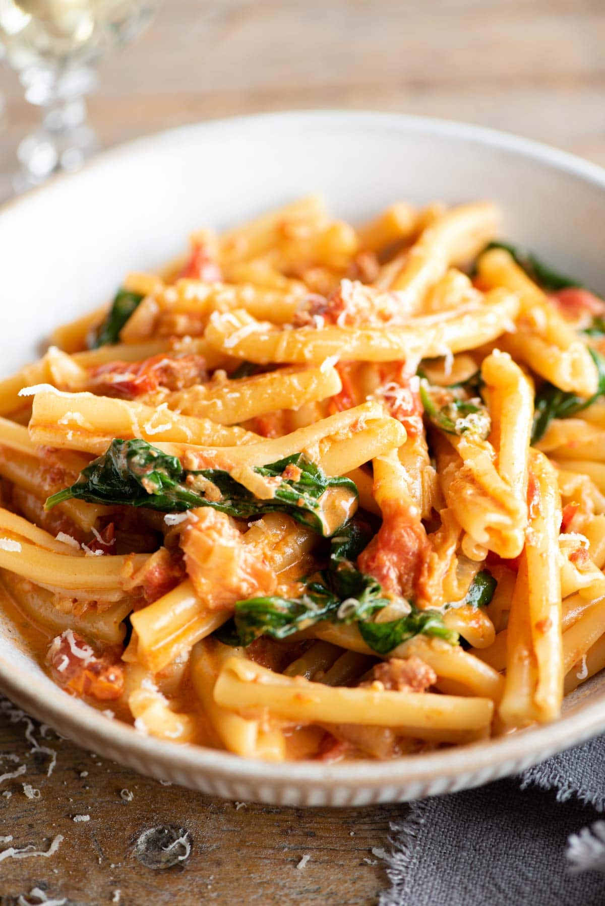 A close up of pasta with Nduja sauce, spinach and tomatoes