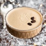 A close up of a Martini Macchiato cocktail in a glass topped with coffee beans
