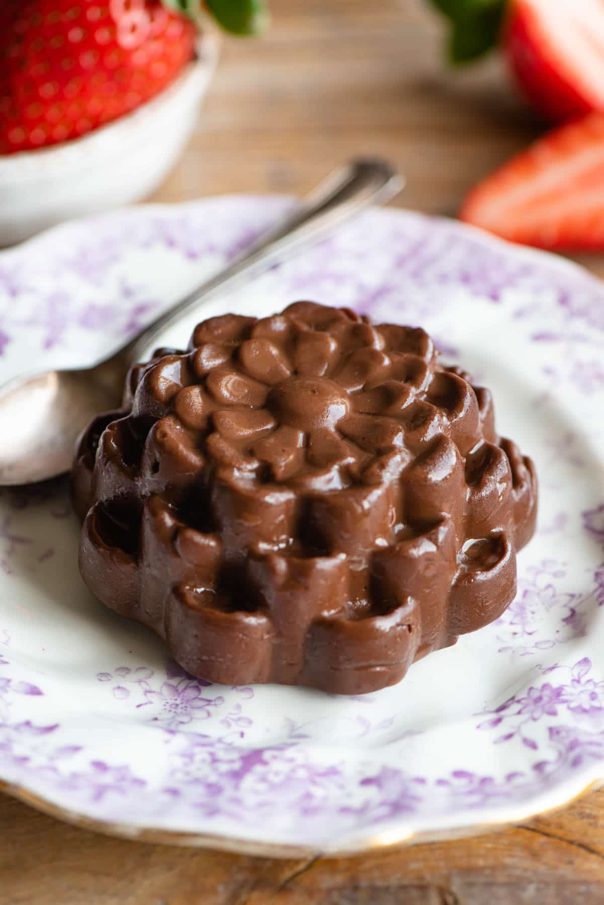 Chocolate budino in the shape of a flower on a pink and white plate