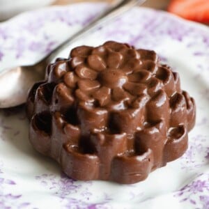 A chocolate budino on a small pink and white patterned plate