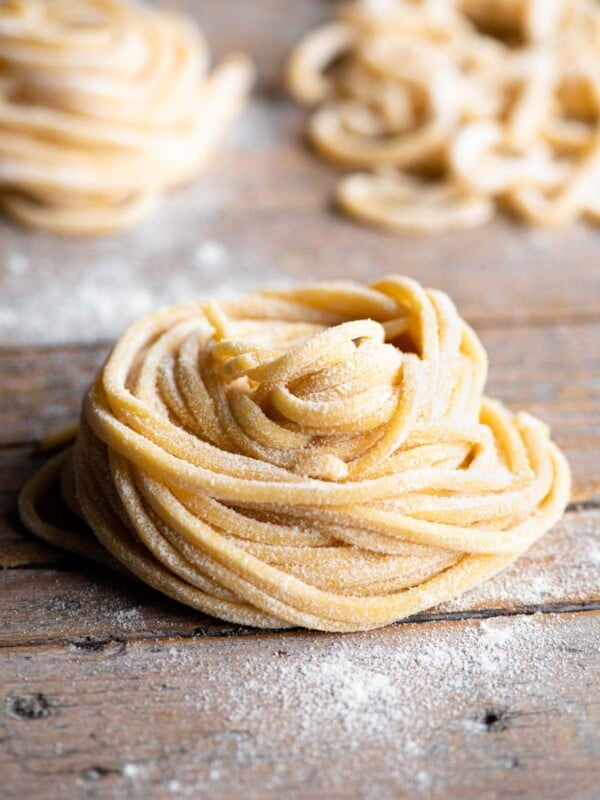 A nest of tonnarelli pasta sitting on a wooden surface