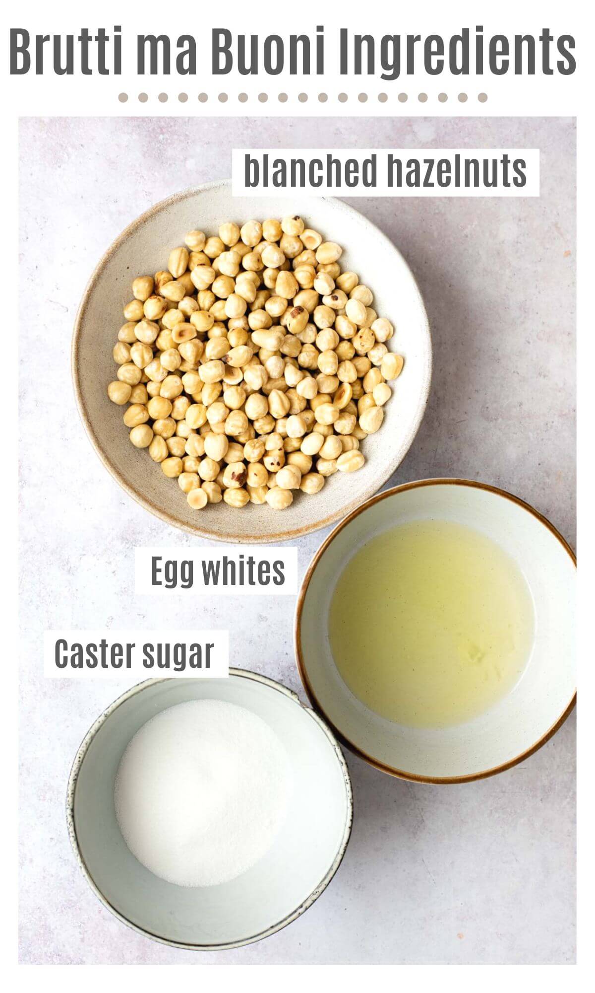 An overhead shot of three bowls containing blanched hazelnuts, egg whites and sugar