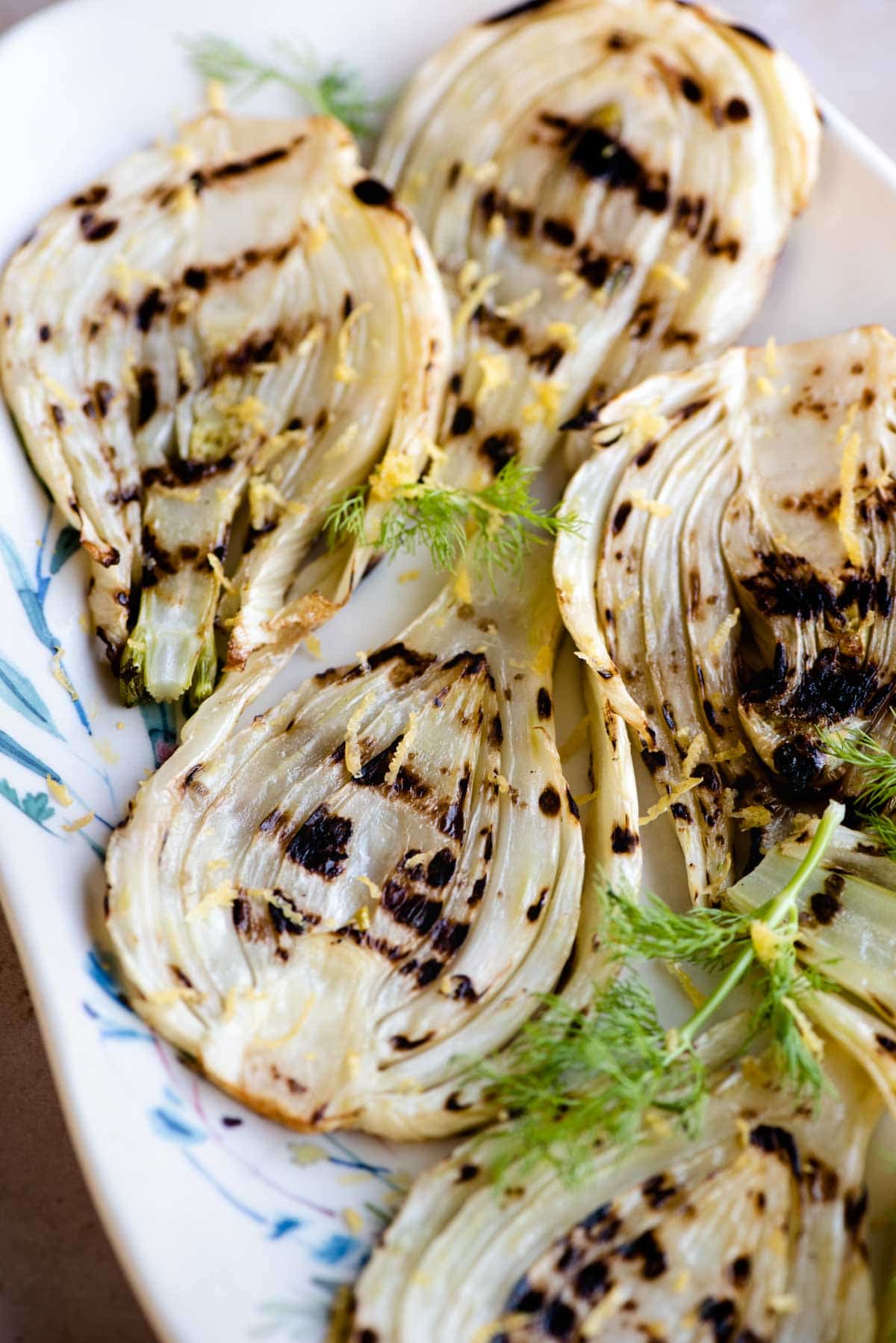 A close up of grilled fennel on a white serving dish