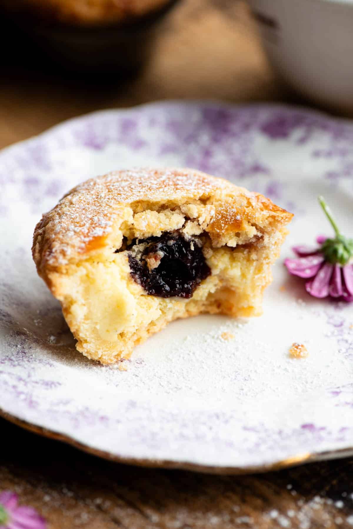 A Pasticciotto pastry cut in half showing the pastry cream and cherry inside.