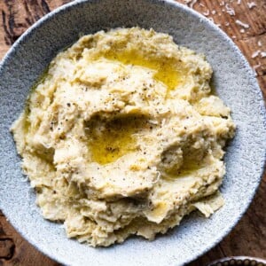 A close up square image of artichoke pesto in a bowl.