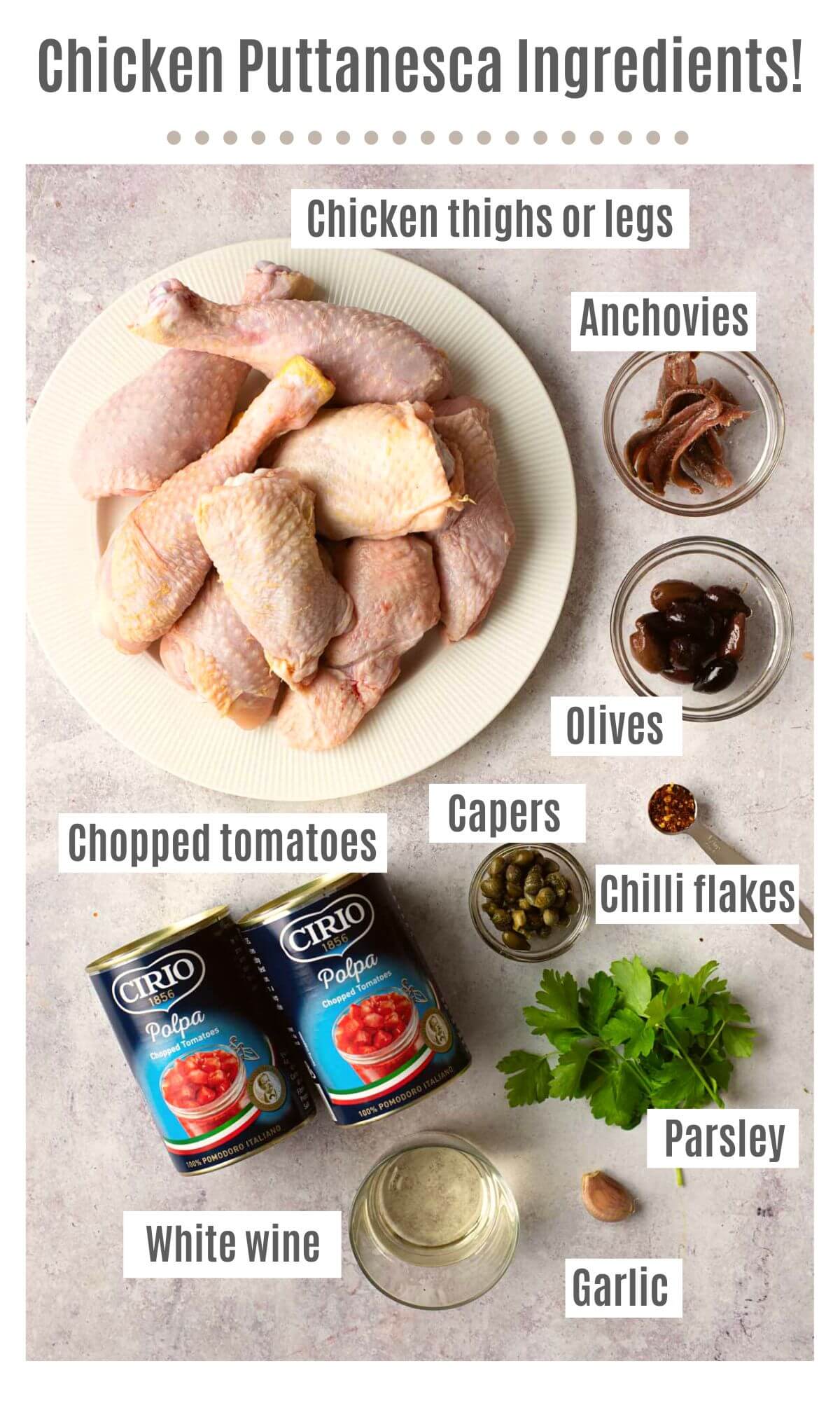 An overhead shot of labelled ingredients needed to make chicken puttanesca; chicken thighs or legs, anchovies, olives, capers, chilli flakes, chopped tomatoes, parsley, garlic and white wine.