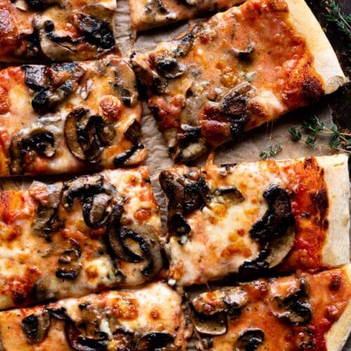 An overhead shot of a Taleggio and Mushroom Pizza cut into 8 slices.