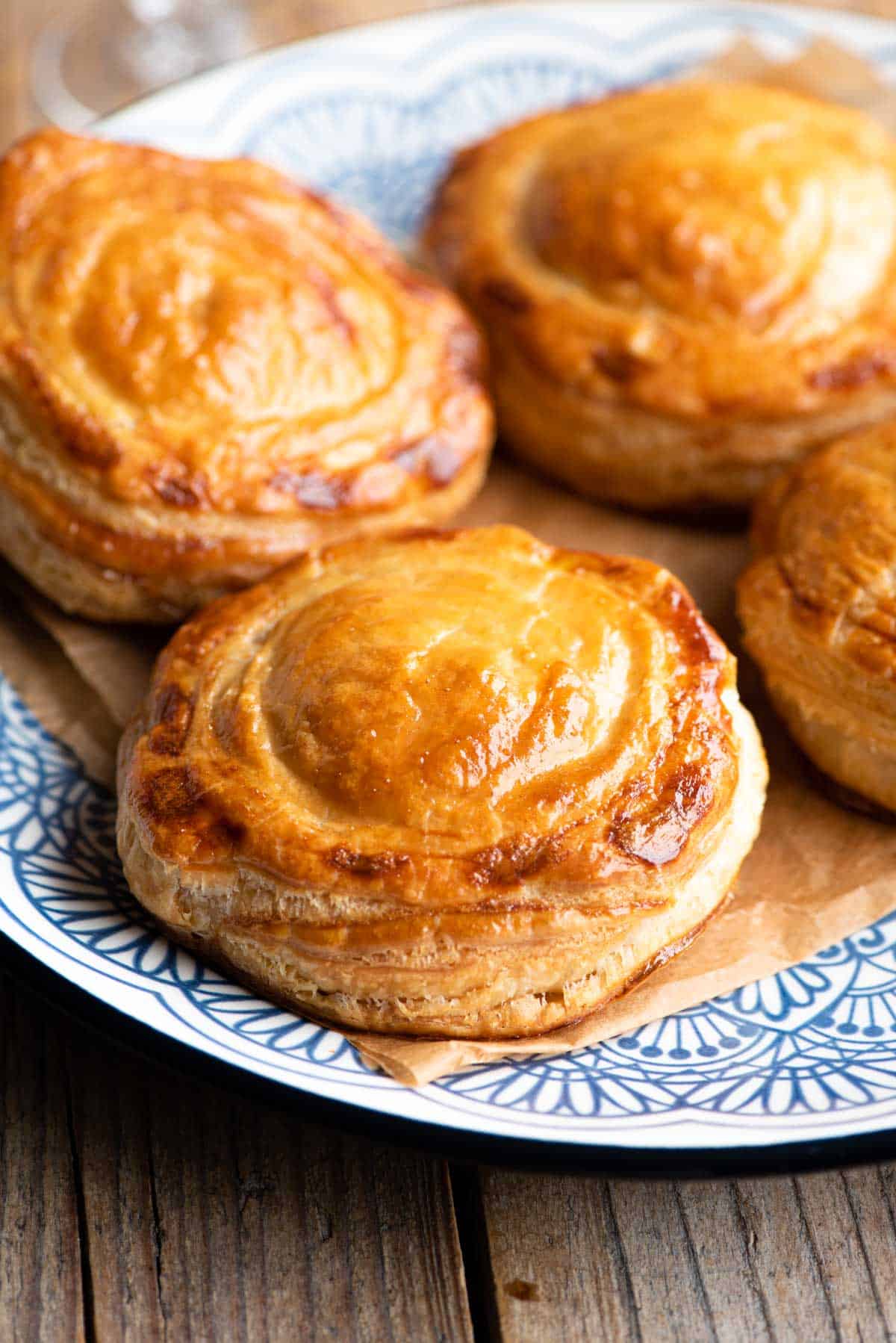 Four Rustici Leccesi (Italian pastries) on a blue plate.